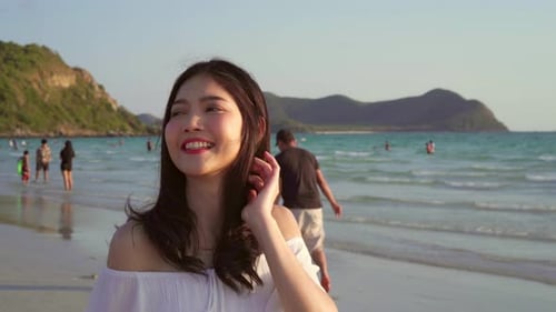 Beautiful female happy relax walking on beach near sea when sunset in evening.