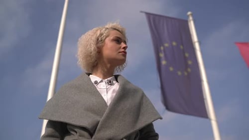 Businesswoman standing near waving flag