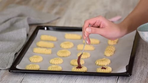 Female Hands a Making Homemade Biscuit Shortbread Cookies with Jam. Kurabye Cookies with Raspberry
