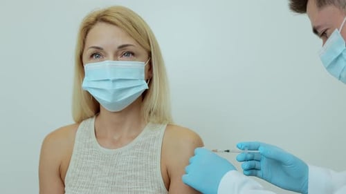 Doctor Doing Vaccine Injection to a Female Patient in a Health Clinic