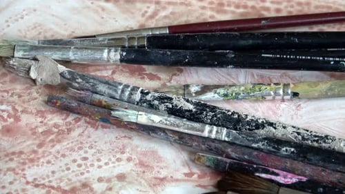 Used Paint Brushes Lying on Painted Surface