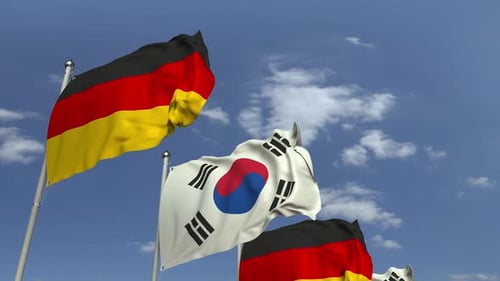 Flags of Germany and South Korea Waving in Blue Sky