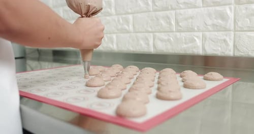 Piping Macarons in Professional Bright Kitchen