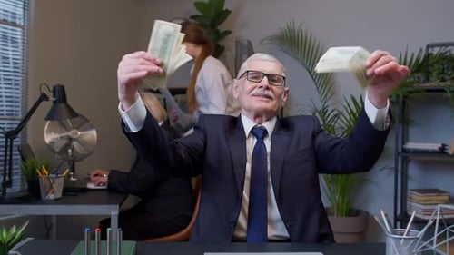 Successful Businessman Celebrates With Cash in Office
