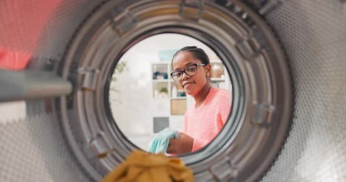 Young Woman Loading Clothes in Washing Machine