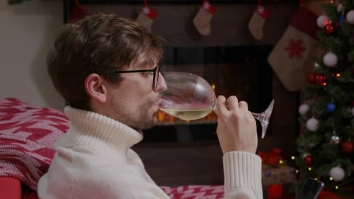 Man Relaxing with Wine by Christmas Tree