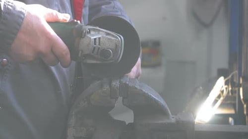 Craftsman Sawing Metal with Disk Grinder in Workshop. Man Worked Over the Steel