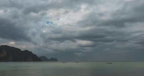Zeitraffer von Regenwolken über Strand und Meereslandschaft mit Booten. Tropischer Sturm im Meer.