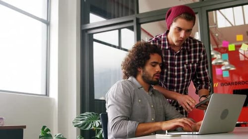 Men Collaborating Using Laptop and Tablet in Office