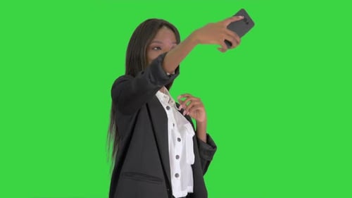 Pretty African Amerivan Female Making Selfie on Her Phone on a Green Screen, Chroma Key.