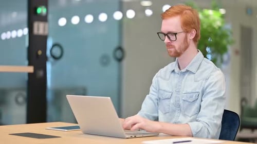 Tired Young Redhead Man with Laptop Having Neck Pain in Office