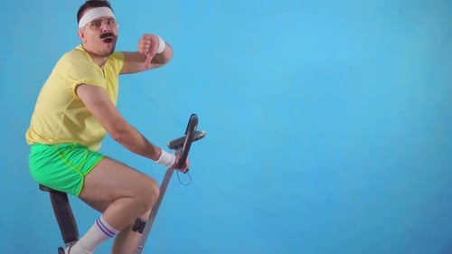 Adult on Exercise Bike Gives Thumbs Down