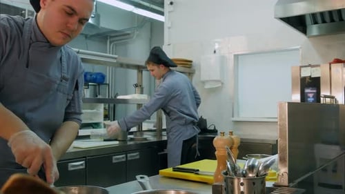 Three Busy Male Cooks Working in the Restaurant Kitchen