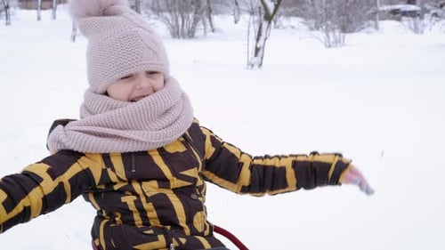 Happy Child Sledding in the Snow on Winter Day