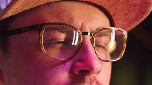 Man Eyes in Pink Neonlicht Nahaufnahme Männlicher Spieler mit Brille spielt Computerspiel Schauen