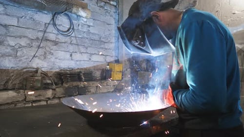 Man in Mask Welding Metal at Workplace