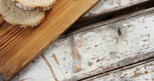 Bread and Knife on a Wooden Cutting Board