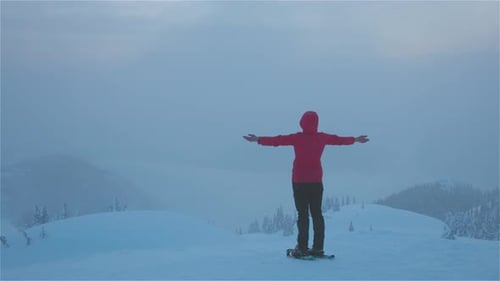 Adventure Girl With Snowshoes Hiking on Top of the Mountain