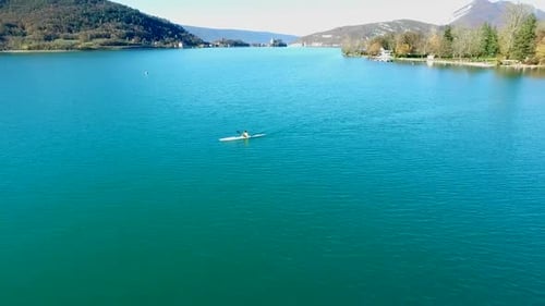 A kayaker paddles in a scenic mountain lake.
