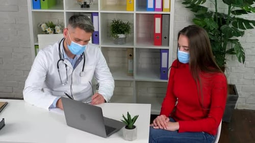 Doctor and patient wears protective masks on faces in hospital communicates talk