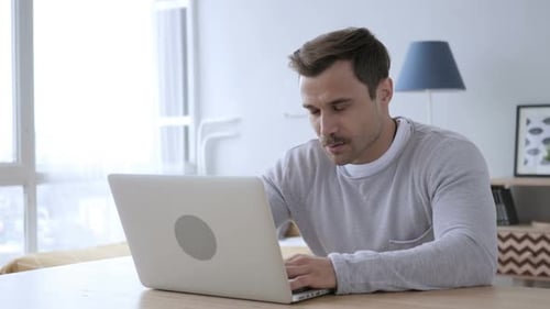 Man Working at Laptop Computer at Home Office