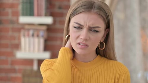 Young Woman Rubbing Neck in Discomfort