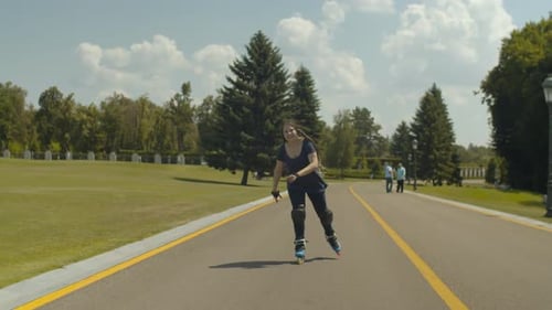Active Young Woman Riding on Roller Blades in Park