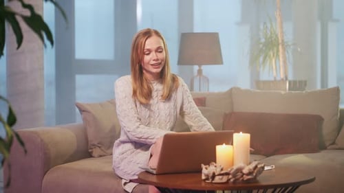 Smiling Woman Using Laptop in Cozy Home Setting