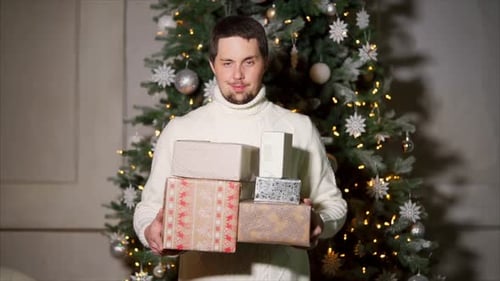 Man Holding Christmas Presents by Decorated Tree
