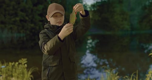 Little Fisher Boy sieht seinen Fischfang mit kleinen Fischen in Händen Prores