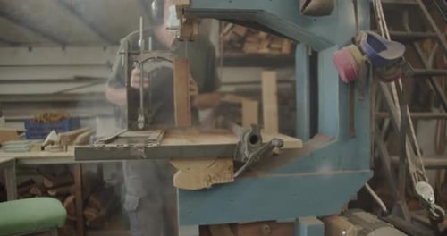 Man Cuts Wood with Machine in Workshop
