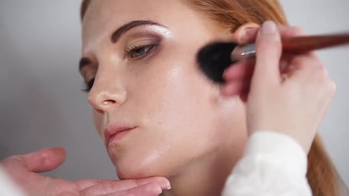 Makeup Artist Applying Blush to Woman