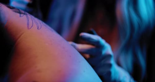 Tattooist explaining a client about a tattoo process in a studio. BMPCC 4K