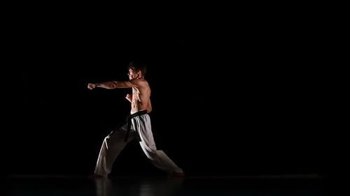 Man trainiert Taekwondo oder Karate isoliert auf schwarzem Hintergrund. Zeitlupe