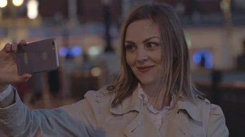 Woman Taking Selfie in City at Night