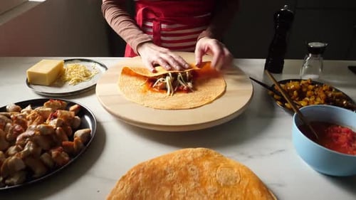 Frau macht Burritos auf dem Küchentisch