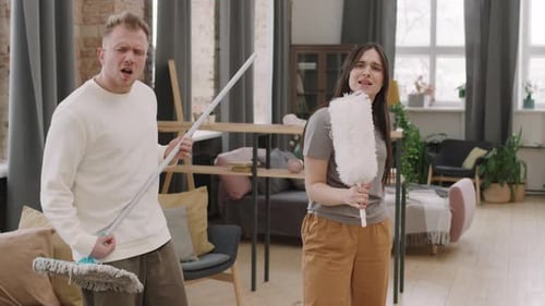 Couple Singing with Cleaning Tools as Microphones