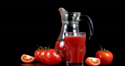 Tomatensaft in Glas und Krug rotiert langsam