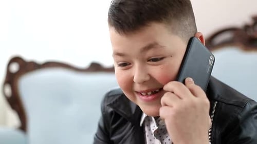 Smiling Boy Talking on a Smartphone Indoors