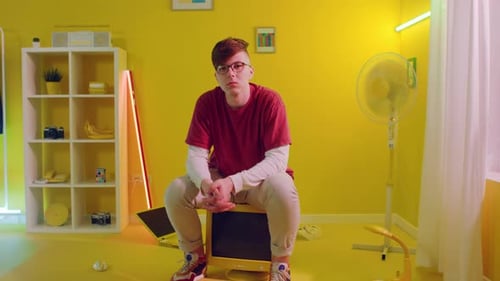 Young Adult Sitting in Yellow Retro Room