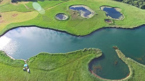 Luftaufnahme von friedlichen Teichen auf einer grünen Wiese