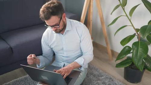Adult with Laptop and Card in Home Setting