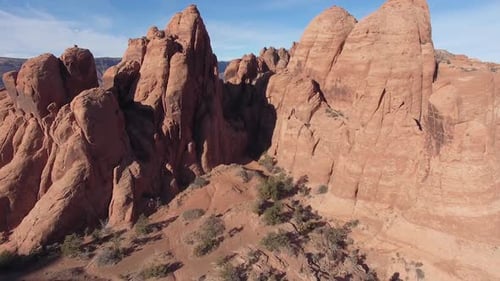 Flying through red rock desert terrain past cliff in Moab Utah