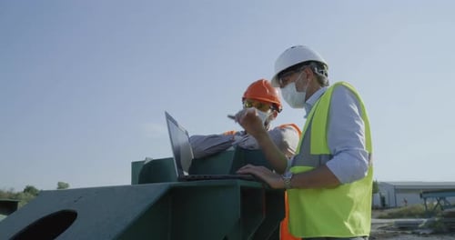 Construction Workers Discussing Project at Construction Site