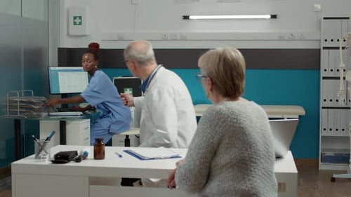 Mediziner und alte Patienten analysieren Knochenradiographie bei Checkup-Besuch