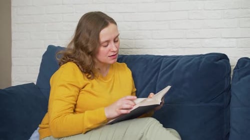 Frau liest begeistert gebundenes Papierbuch