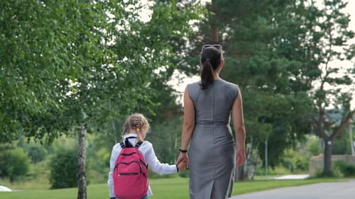 Mutter führt ihre kleine Tochter in die Schule
