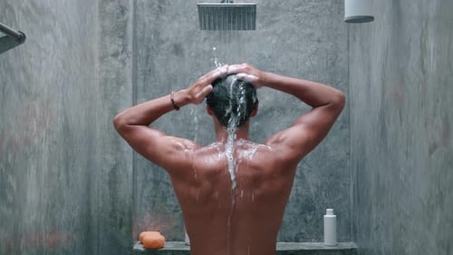 Back View Young Man Washing and Taking a Shower with Shower Bath and Washing Hair with Shampoo in