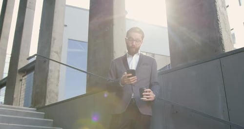 Man Using Mobile Phone Outside Modern Building