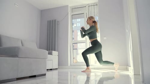 young fitness woman doing squat exercises with lunges from leg to leg.
